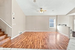 Spacious interior featuring wood-finish flooring, a contemporary ceiling fan, and a single window with horizontal blinds - 