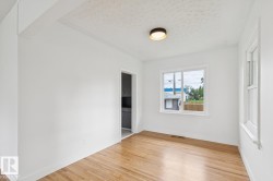 Room featuring wood-finish flooring and bright white walls - 