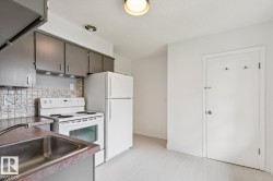 Kitchen featuring grey cabinetry, white electric range, white refrigerator, and a stainless steel sink - 