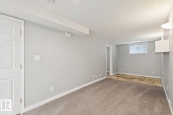 Spacious room featuring light gray walls, white baseboards, and a textured ceiling - 