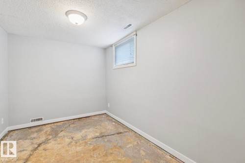 Room featuring light gray walls, a textured ceiling, and a flush-mount ceiling light fixture - 8202 93A Avenue Nw, Edmonton, AB - Indoor Photo Showing Other Room