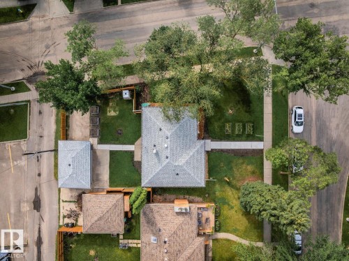 Overhead view of a property featuring a main residence with a gray shingle roof, a detached garage with a matching shingle roof, and a paved driveway - 8202 93A Avenue Nw, Edmonton, AB - Outdoor