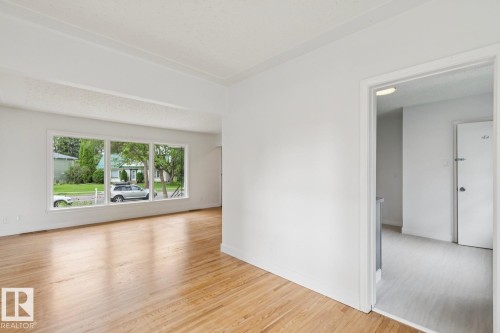 Spacious room featuring light wood flooring and a large picture window - 8202 93A Avenue Nw, Edmonton, AB - Indoor Photo Showing Living Room