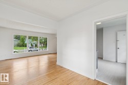 Spacious room featuring light wood flooring and a large picture window - 