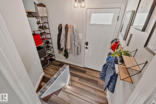 Entryway featuring a white paneled door with frosted glass insert, wood-finish flooring, and overhead flush-mount lighting - 4723 105 Street Nw, Edmonton, AB - Indoor Photo Showing Other Room