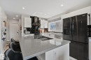 Kitchen featuring a large island with an undermount sink, light-toned countertop, and matte black faucet - 4723 105 Street Nw, Edmonton, AB  - Indoor Photo Showing Kitchen With Double Sink With Upgraded Kitchen 