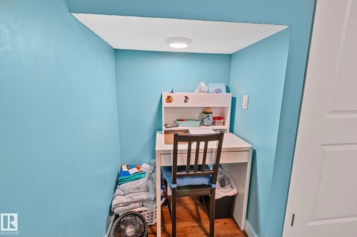 Built-in desk nook featuring a light blue wall finish, recessed lighting, and wood-finish flooring - 4723 105 Street Nw, Edmonton, AB - Indoor