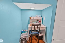 Built-in desk nook featuring a light blue wall finish, recessed lighting, and wood-finish flooring - 