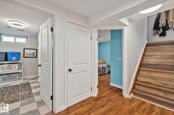 Wood-finish flooring throughout, complemented by a light wood-tone staircase with white risers - 
