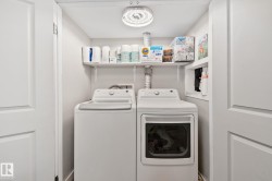Dedicated laundry area featuring a washer and dryer, built-in shelving, and a ceiling-mounted light fixture - 