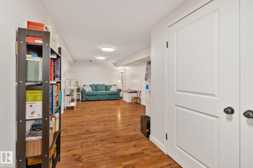 Spacious room featuring wood-finish flooring, recessed lighting, and white panel doors - 4723 105 Street Nw, Edmonton, AB - Indoor Photo Showing Other Room