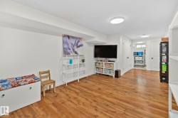 Spacious lower level featuring wood-finish flooring, recessed lighting, and crisp white walls - 