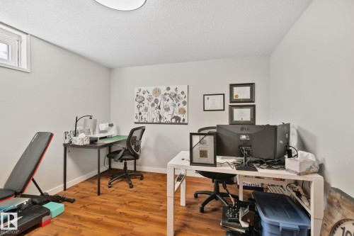 Versatile room featuring wood-finish flooring, light grey painted walls, and a single window with white trim - 4723 105 Street Nw, Edmonton, AB - Indoor Photo Showing Office