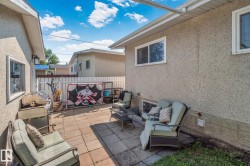Paved patio area featuring block pavers and a white privacy fence - 