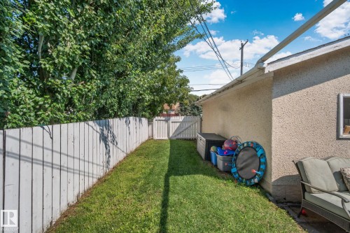 Lush green lawn bordered by a white privacy fence - 4723 105 Street Nw, Edmonton, AB - Outdoor