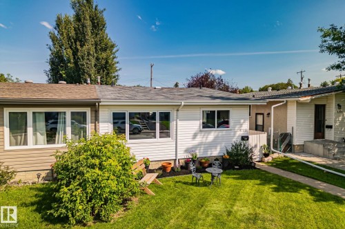 Front exterior featuring horizontal siding, a well-maintained lawn, multiple window units, and a paved walkway leading to the entrance - 4723 105 Street Nw, Edmonton, AB - Outdoor