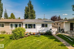 Front exterior featuring white horizontal siding, a gray shingle roof, and a neatly maintained lawn - 