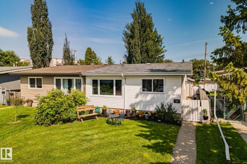 Front exterior featuring white horizontal siding, a gabled roofline, and a manicured front lawn - 4723 105 Street Nw, Edmonton, AB - Outdoor