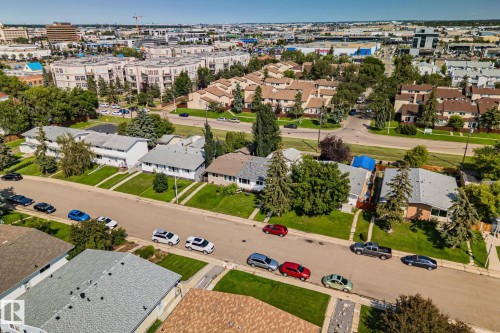 Aerial view showcasing a residential street with single-family homes and multi-story residential buildings in the background - 4723 105 Street Nw, Edmonton, AB - Outdoor With View