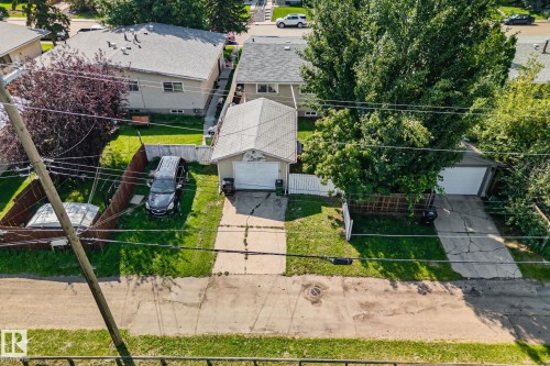 Aerial perspective showcasing two detached garage structures, each with a concrete driveway and surrounding green lawn - 4723 105 Street Nw, Edmonton, AB - Outdoor