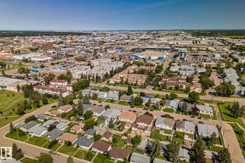 Aerial perspective showcasing a residential neighborhood with single-story and two-story homes, interspersed with green spaces and mature trees - 4723 105 Street Nw, Edmonton, AB - Outdoor With View