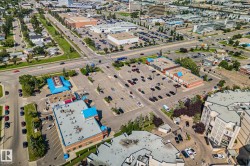 Aerial perspective of a commercial area featuring multiple retail buildings with parking lots - 