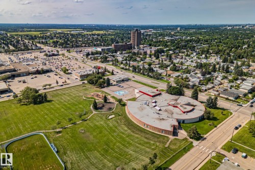 Aerial perspective showcasing an expansive green space with a track, surrounded by residential areas and commercial establishments - 4723 105 Street Nw, Edmonton, AB - Outdoor With View