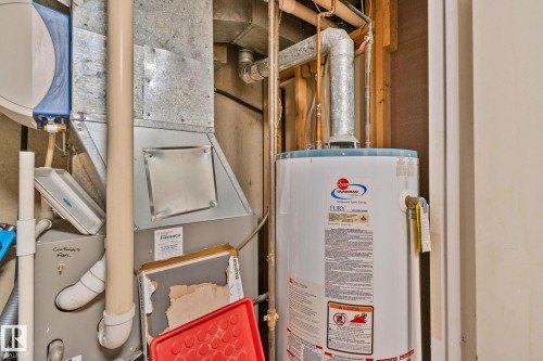 Utility area featuring a water heater, furnace, and exposed copper piping - 4723 105 Street Nw, Edmonton, AB - Indoor Photo Showing Basement
