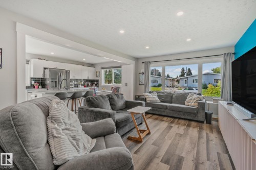 Open-concept living space featuring wood-finish flooring, recessed lighting, and large windows - 4723 105 Street Nw, Edmonton, AB - Indoor Photo Showing Living Room