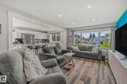 Open-concept living space featuring wood-finish flooring, recessed lighting, and large windows - 