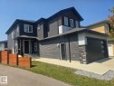 Contemporary multi-level residence featuring dark siding, a covered entry, and a two-car garage with modern window panels - 228 36 Street Sw, Edmonton, AB  - Outdoor 