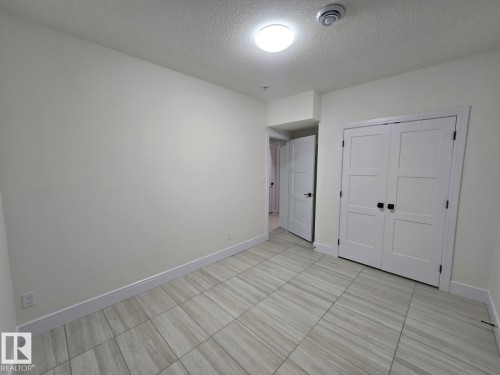 Light-toned tile flooring throughout - 228 36 Street Sw, Edmonton, AB - Indoor Photo Showing Other Room