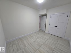 Room featuring light-colored walls and wood-finish tile flooring - 