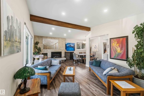 Vaulted ceiling with an exposed wood beam, recessed lighting, and wood-finish flooring - 11351 35A Avenue Nw, Edmonton, AB - Indoor Photo Showing Living Room With Fireplace
