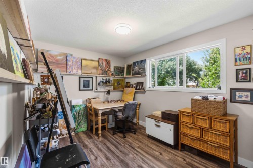 Versatile interior space featuring wood-finish flooring, a large window, recessed lighting, and wall-mounted shelving - 11351 35A Avenue Nw, Edmonton, AB - Indoor Photo Showing Office
