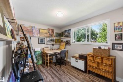 Versatile interior space featuring wood-finish flooring, a large window, recessed lighting, and wall-mounted shelving - 