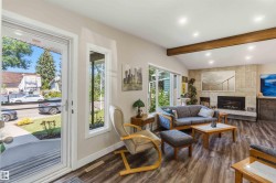 Vaulted ceiling living area featuring a stone-clad fireplace, exposed wood beam, recessed lighting, and wood-finish flooring - 