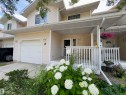 Exterior featuring a covered porch, white railing, and a single-car garage - #48 6608 158 Av Nw, Edmonton, AB  - Outdoor With Facade 