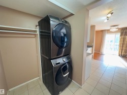 Dedicated laundry area featuring a stacked washer and dryer unit - 