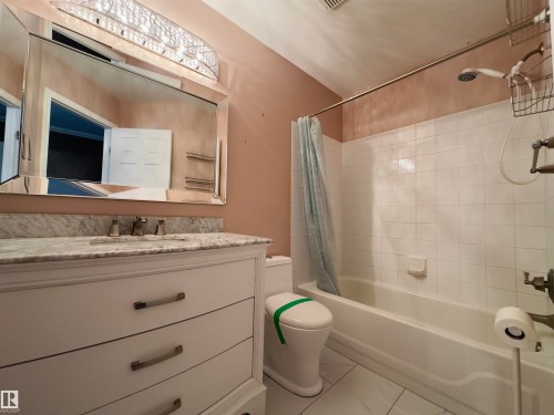 Bathroom vanity featuring a light-toned countertop with integrated sink and a chrome faucet set - #48 6608 158 Av Nw, Edmonton, AB - Indoor Photo Showing Bathroom