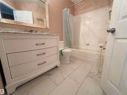 White vanity with a stone-finish countertop and brushed nickel hardware - 