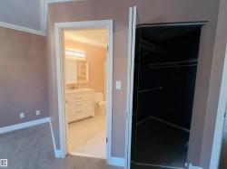 Bathroom entry featuring a white vanity with integrated sink, chrome faucet, and decorative light fixture - 