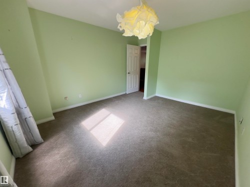 Neutral-toned carpet flooring - #48 6608 158 Av Nw, Edmonton, AB - Indoor Photo Showing Other Room