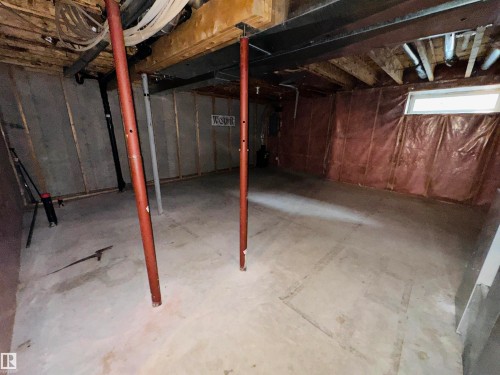 Unfinished lower level featuring exposed wooden ceiling joists, concrete flooring, and perimeter wall insulation - #48 6608 158 Av Nw, Edmonton, AB - Indoor Photo Showing Basement