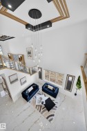 Soaring ceilings with a multi-tiered chandelier, recessed lighting, and decorative wood-finish ceiling accents - 