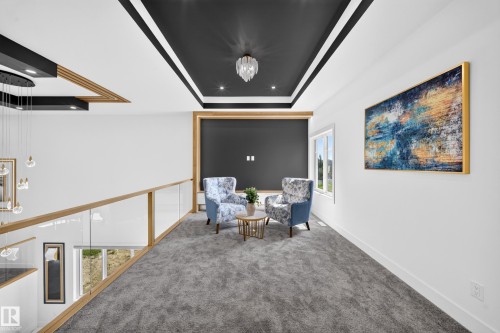 Carpeted upper-level hall featuring a black tray ceiling with recessed lighting and a central chandelier - 423 Robinson Bv, Leduc, AB - Indoor Photo Showing Other Room