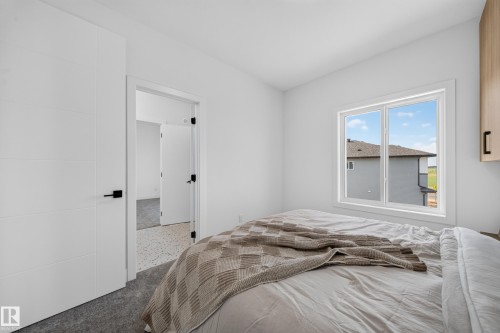 Bright interior with white walls, a multi-pane window, and light grey carpeting - 423 Robinson Bv, Leduc, AB - Indoor Photo Showing Bedroom