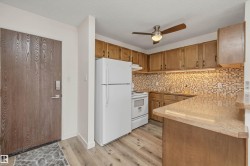 Kitchen featuring wood-finish cabinetry, mosaic tile backsplash, and light-toned countertops - 