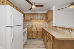 Kitchen featuring a built-in breakfast bar, wood-finish cabinetry, and a mosaic tile backsplash - 