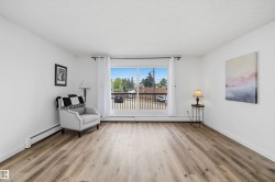 Spacious room featuring wood-finish flooring and a large window with a black railing - 